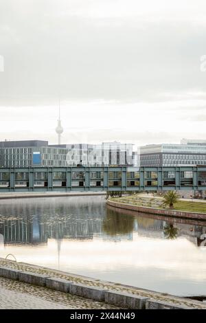 Homme d'affaires cyclant sur le pont sur le canal contre le ciel dans la ville Banque D'Images