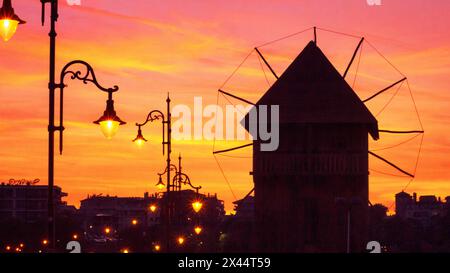 Paysage de ville en soirée - vue sur les silhouettes du moulin à vent en bois et des lampadaires sur le remblai de Nessebar avant l'entrée dans le Vieux Banque D'Images