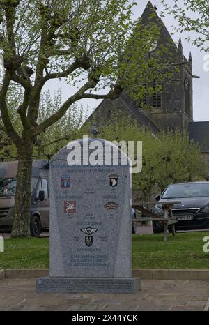 Sainte-Mere-Eglise, France - 19 avril 2024 : Eglise Sainte-Mere-Eglise. Des gens marchant à Sainte-Mere-Eglise. Rues et bâtiments. Style de vie dans l'ur Banque D'Images