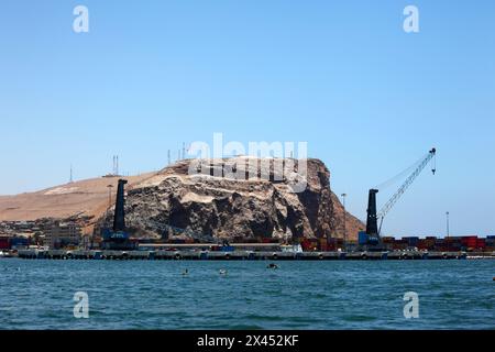 Grues pour soulever des conteneurs sur le quai dans le port, promontoire El Morro en arrière-plan, Arica, Chili Banque D'Images