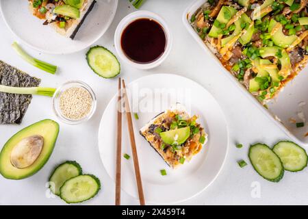 Philadelphia Sushi Bake recette casserole à base de riz, fromage à la crème, truite saumon, algues, avocat, sauce, oignon vert. Servi avec des feuilles de nori grillées Banque D'Images