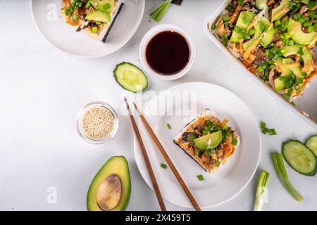 Philadelphia Sushi Bake recette casserole à base de riz, fromage à la crème, truite saumon, algues, avocat, sauce, oignon vert. Servi avec des feuilles de nori grillées Banque D'Images