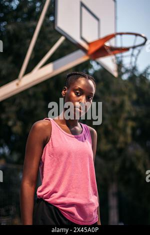 Portrait d'une joueuse de basket-ball afro-américaine confiante sur le terrain le soir Banque D'Images