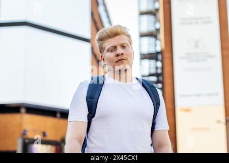 Portrait d'un jeune latin albinos avec des vêtements blancs et sac à dos dans la ville Banque D'Images