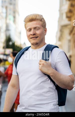 Portrait d'un jeune latin albinos avec des vêtements blancs et sac à dos dans la ville Banque D'Images