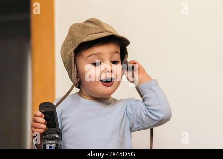 adorable bébé avec un chapeau jouant avec un mobile Banque D'Images