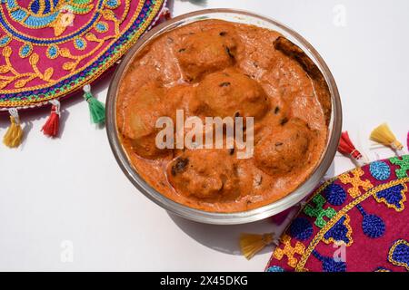 Cuisine indienne - Cachemire Dum Aloo ou pommes de terre en sauce rouge servies dans un bol. Punjabi dum aloo vue de dessus sur fond blanc Banque D'Images