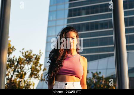 Portrait d'une jeune brésilienne regardant la caméra debout à l'extérieur dans la ville vêtue de vêtements d'été Banque D'Images