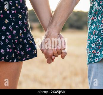 Magnifique gros plan sur une vieille dame écorchée tenant les mains de sa petite-fille. Gros plan d'une main ridée et des mains d'un jeune tenant. Banque D'Images