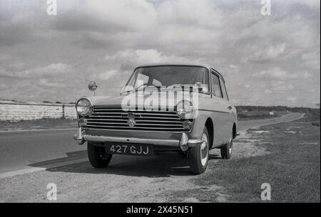 Années 1960, historique, une Austin A40 voiture de l'époque garée à côté d'une route A dans le Dorset, Angleterre, Royaume-Uni. Fabriqué par la British Motor Corporation (BMC), l'A40 a été introduit en 1958, avec un style par une société italienne, Pininfarina. La petite voiture familiale était en production, avec différents modèles, jusqu'en 1967. Banque D'Images