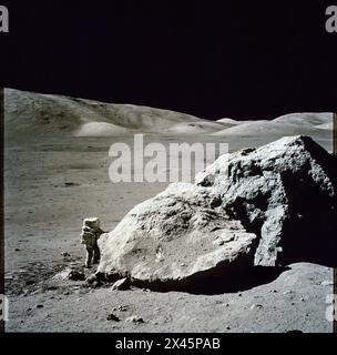 L'astronaute Harrison H. Schmitt se tenant à côté d'un énorme rocher lunaire divisé sur la lune lors du troisième Apollo 17 1972 Banque D'Images