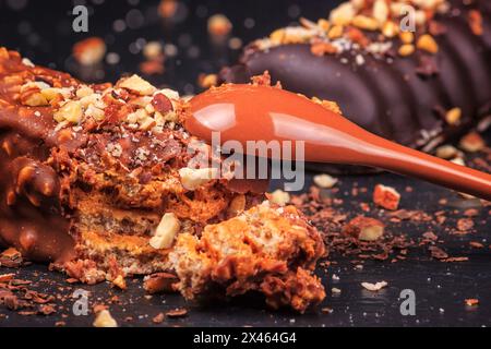Le gâteau au chocolat apparaît avec des noix sous forme de popsicle sur le bâton sur fond de tableau noir d'ardoise, gros plan. Сan Voir la texture interne. Banque D'Images