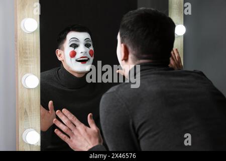 Artiste MIME posant près du miroir dans le dressing Banque D'Images