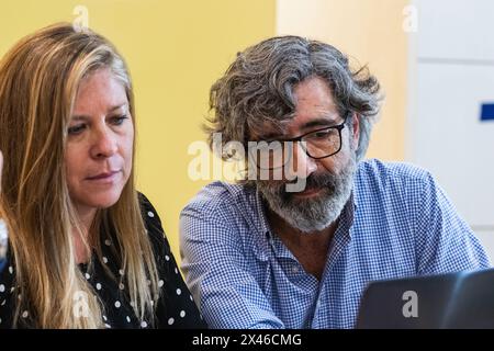 Des collègues matures et concentrés assis à table et utilisant un netbook tout en travaillant sur un nouveau projet sur le lieu de travail Banque D'Images