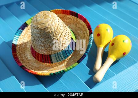 Chapeau sombrero mexicain et maracas sur surface en bois bleu Banque D'Images