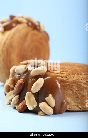 Croissants suprêmes avec de la pâte de chocolat et des noix sur fond bleu clair, gros plan. Pâte feuilletée savoureuse Banque D'Images