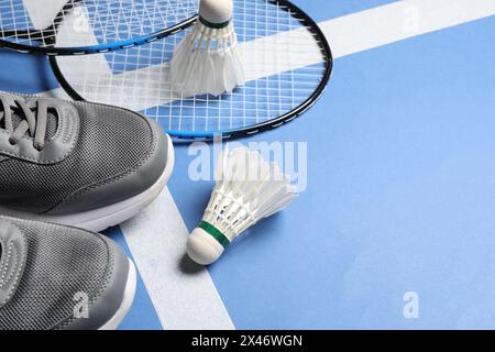 Volants de badminton en plumes, raquettes et baskets sur le court, espace pour le texte Banque D'Images