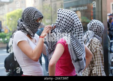 New York, États-Unis. 30 avril 2024. Les manifestants pro-palestiniens s'entraident à mettre des foulards Palestine Keffiyeh lorsqu'ils se rassemblent devant l'entrée de Broadway de l'Université Columbia à New York le mardi 30 avril 2024. Des manifestants étudiants pro-palestiniens ont occupé le bâtiment Hamilton Hall pendant la nuit et ont refusé de quitter les lieux. Les manifestations pro-palestiniennes se poursuivent depuis près de 2 semaines sur le campus de l'école. Photo de John Angelillo/UPI crédit : UPI/Alamy Live News Banque D'Images