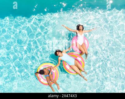 Couple biracial profite d'une journée ensoleillée dans la piscine, avec espace copie Banque D'Images