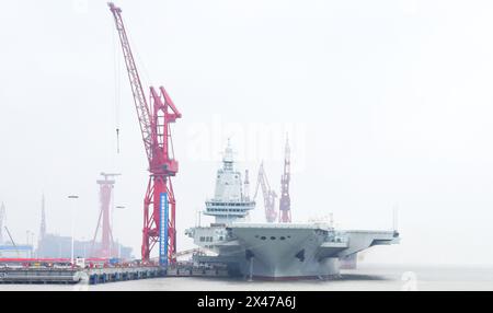 (240501) -- SHANGHAI, 1er mai 2024 (Xinhua) -- le troisième porte-avions chinois, le Fujian, accoste à Shanghai, dans l'est de la Chine, le 30 avril 2024. Le troisième porte-avions de la Chine, le Fujian, s'est lancé mercredi matin pour ses premiers essais en mer. Le navire a quitté Shanghai vers 8 heures. Les essais en mer testeront principalement la fiabilité et la stabilité des systèmes de propulsion et électriques du porte-avions. Depuis son lancement en juin 2022, le Fujian a terminé ses essais d'amarrage, ses travaux d'équipement et ses ajustements d'équipement. Il a satisfait aux exigences techniques pour les essais en mer. (Xinhua/Li Yun) Banque D'Images