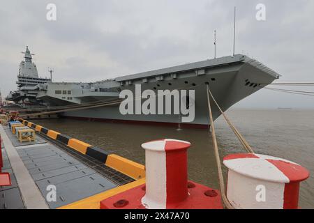 (240501) -- SHANGHAI, 1er mai 2024 (Xinhua) -- le troisième porte-avions chinois, le Fujian, accoste à Shanghai, dans l'est de la Chine, le 30 avril 2024. Le troisième porte-avions de la Chine, le Fujian, s'est lancé mercredi matin pour ses premiers essais en mer. Le navire a quitté Shanghai vers 8 heures. Les essais en mer testeront principalement la fiabilité et la stabilité des systèmes de propulsion et électriques du porte-avions. Depuis son lancement en juin 2022, le Fujian a terminé ses essais d'amarrage, ses travaux d'équipement et ses ajustements d'équipement. Il a satisfait aux exigences techniques pour les essais en mer. (Photo de pu Haiyang Banque D'Images