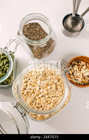 Flocons d'avoine, chia et graines de citrouille dans des bocaux en verre, ingrédients nutritionnels sains Banque D'Images