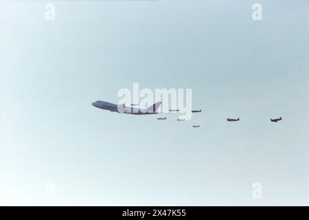 Northwest Orient Airlines Boeing 747 Jumbo Jet N637US volant en formation avec un groupe d'avions de chasse de la seconde Guerre mondiale lors du spectacle aérien North Weald Fighter Meet en 1986. Un événement unique organisé pour célébrer le 60e anniversaire de Northwest Orient Airlines. Deux avions de chasse de la seconde Guerre mondiale comprenaient un Spitfire, un Mustang, un Thunderbolt et un Corsair Banque D'Images