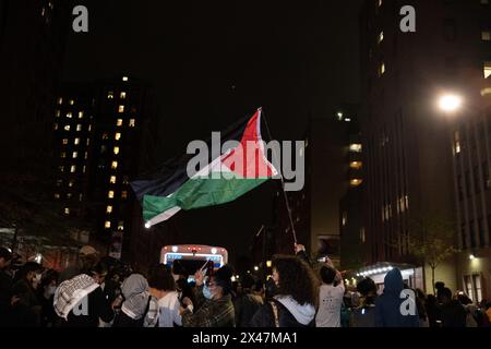 New York, États-Unis. 30 avril 2024. Un manifestant arbore un drapeau palestinien dans le corwd. Le bus des corrections NYPD peut être vu derrière eux. L’Université Columbia appelle le NYPD à « rétablir la sécurité et l’ordre dans notre communauté » après que des manifestants pro-palestiniens aient occupé Hamilton Hall pendant la nuit. La salle a été vandalisée et bloquée et tout le personnel de sécurité a été forcé de quitter le bâtiment. (Photo de Syndi Pilar/SOPA images/SIPA USA) crédit : SIPA USA/Alamy Live News Banque D'Images