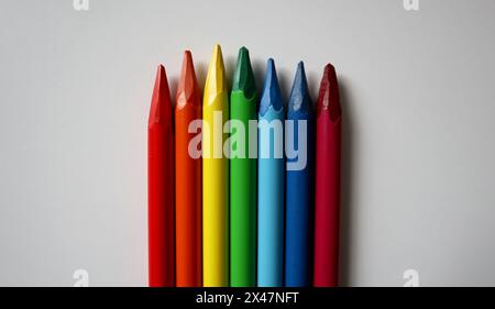 Photo de crayons de couleur disposés dans les couleurs de l'arc-en-ciel sur fond blanc. Crayons sans bois. Les crayons sont placés au milieu à partir du bas de l'arrière-plan. Différentes tailles. Banque D'Images