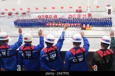 (240501) -- SHANGHAI, 1er mai 2024 (Xinhua) -- les gens font signe d'adieu aux membres du personnel qui assistent aux premiers essais en mer du troisième porte-avions chinois, le Fujian, à un quai dans l'est de la Chine Shanghai le 1er mai 2024. Le troisième porte-avions de la Chine, le Fujian, s'est lancé mercredi matin pour ses premiers essais en mer. Les essais en mer porteront principalement sur la fiabilité et la stabilité des systèmes de propulsion et électriques du porte-avions. Depuis son lancement en juin 2022, le Fujian a terminé ses essais d'amarrage, ses travaux d'équipement et ses ajustements d'équipement. Il a satisfait aux exigences techniques pour se Banque D'Images