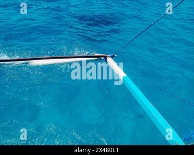 Gros plan des stabilisateurs de bambou d'une banca philippine ou bangka sur les eaux cristallines de Siargao. Banque D'Images