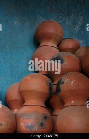 les pots sont rassemblés et disposés selon un motif dans l'espace vide. Le potier travaille sur une roue de poterie à faire de l'argile de couleur douce, style rétro tonique Cl Banque D'Images