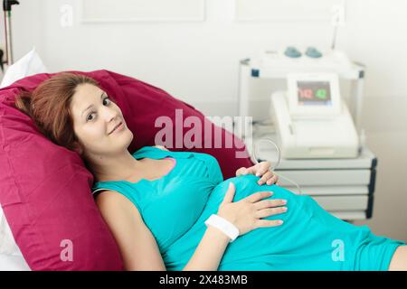 Mère donnant naissance à un bébé. Patiente enceinte hospitalière lors d'une visite médicale. Moniteur foetal électronique de grossesse et échographie. Banque D'Images