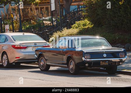 Ford Mustang classique garé dans la rue de la ville, vintage rencontre le moderne à San Francisco. Banque D'Images