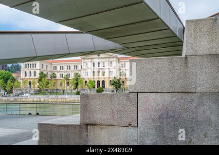 BILBAO, ESPAGNE - 10 MAI 2014 : la passerelle piétonne Pedro Arrupe sur la rivière Nervion à Bilbao, pays Basque, Espagne, avec l'Université de Deus Banque D'Images