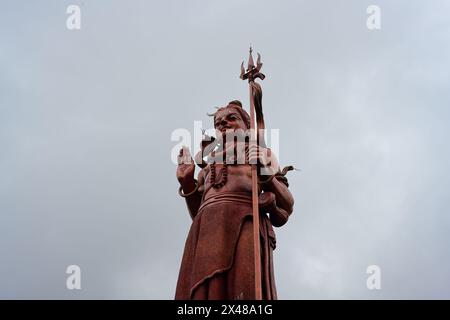 Statue de Shiva Seigneur rouge avec Trident à Ganga Talao ou Grand bassin Maurice Banque D'Images