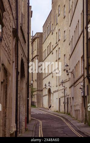 23 avril 24 Une rue étroite flanquée de grands bâtiments en pierre dans la ville historique de Bath dans le Somerset Angleterre Banque D'Images