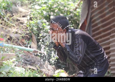 Dhaka. 1er mai 2024. Un jeune homme utilise de l’eau pour se rafraîchir à Dhaka, Bangladesh, le 30 avril 2024. Le Bangladesh a établi son record de températures extrêmes cette année alors que la canicule balaye de grandes parties du pays sud-asiatique. Le mercure a atteint 43,8 degrés Celsius mardi, dans le district sud-ouest du pays de Jessore, un record depuis 1989, selon le Département météorologique du Bangladesh (BMD). Crédit : Xinhua/Alamy Live News Banque D'Images