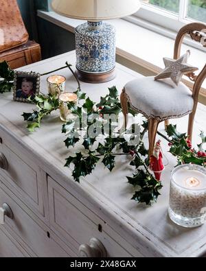 Chaise et houx sur buffet dans la maison de la famille Dorset à Noël, Angleterre, Royaume-Uni Banque D'Images