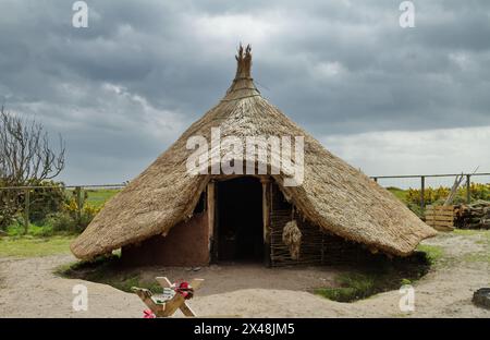 Reconstruction d'une maison ronde de l'âge du fer avec toit conique en chaume et murs Wattle et Daub partiellement finis, Hengistbury Head, Royaume-Uni Banque D'Images