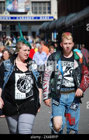 Punk Rockers présentant une mode unique dans une rue animée de la ville Banque D'Images