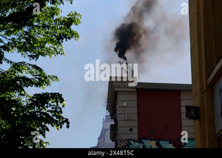 Hambourg, Allemagne. 01 mai 2024. Un homme masqué brûle des pièces pyrotechniques lors d'une manifestation de groupes de gauche le 1er mai à la Rote Flora dans le Schanzenviertel. Crédit : Axel Heimken/dpa/Alamy Live News Banque D'Images