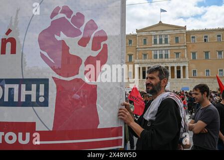 Rassemblement du 1er mai Un manifestant tient une banderole représentant un poing levé devant le Parlement grec lors de la manifestation de la Journée internationale des Wokers. Athènes Grèce Copyright : xNicolasxKoutsokostasxNicolasxKoutsokostasx DSC 202405010096 Banque D'Images