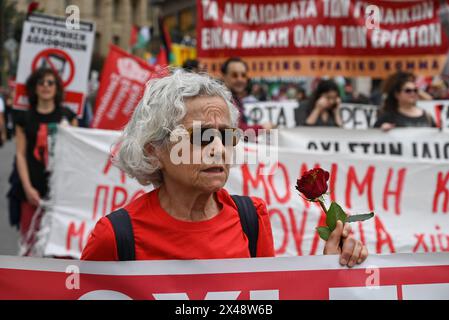 Rassemblement du 1er mai Un manifestant marche dans le centre d'Athènes avec une rose rouge pendant la manifestation de la Journée internationale des sorciers. Athènes Grèce Copyright : xNicolasxKoutsokostasxNicolasxKoutsokostasx DSC 202405010358 Banque D'Images