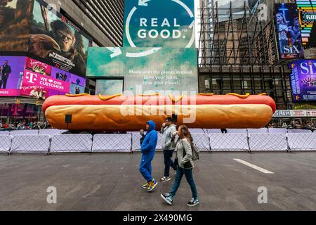 « Hot Dog in the City », par les artistes Jen Catron et Paul Outlaw à Times Square à New York le mardi 30 avril 2024. La sculpture animatronique de hot dog de 65 pieds de long se lève et éjacule des confettis à midi chaque jour. L’installation sera exposée jusqu’au 13 juin.(© Richard B. Levine) Banque D'Images