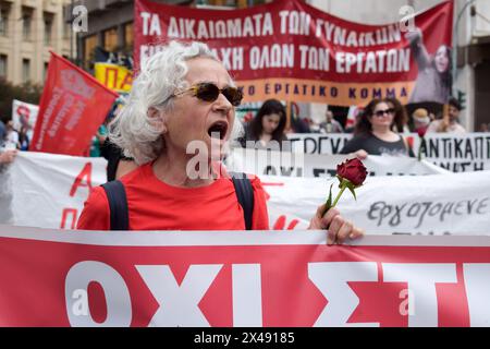 Athènes, Grèce. 1er mai 2024. Une femme crie des slogans tenant une rose rouge pendant le rassemblement de la Journée internationale des sorciers. Des milliers de personnes protestent contre « les prix élevés et la perte de salaires qui conduisent la société à un appauvrissement permanent » lors des rassemblements du 1er mai. Crédit : Dimitris Aspiotis/Alamy Live News Banque D'Images