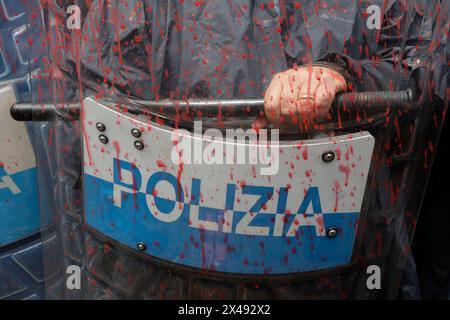 Naples, Italie. 01 mai 2024. Le personnel de police couvert de peinture rouge alors que les manifestants lançaient de la peinture rouge sur la porte d'entrée du siège de l'Union industrielle pendant la procession de la fête du travail. Crédit : Agence photo indépendante/Alamy Live News Banque D'Images