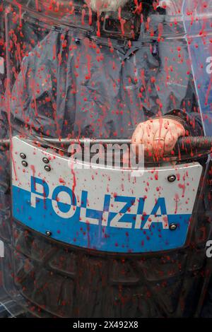 Naples, Italie. 01 mai 2024. Le personnel de police couvert de peinture rouge alors que les manifestants lançaient de la peinture rouge sur la porte d'entrée du siège de l'Union industrielle pendant la procession de la fête du travail. Crédit : Agence photo indépendante/Alamy Live News Banque D'Images