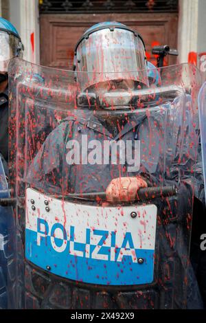 Naples, Italie. 01 mai 2024. Le personnel de police couvert de peinture rouge alors que les manifestants lançaient de la peinture rouge sur la porte d'entrée du siège de l'Union industrielle pendant la procession de la fête du travail. Crédit : Agence photo indépendante/Alamy Live News Banque D'Images