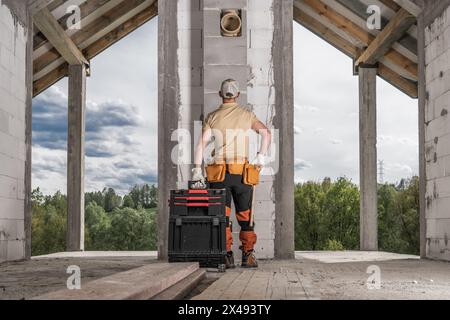 Travailleur professionnel de brique se préparant pour une autre journée sur un chantier de construction Banque D'Images